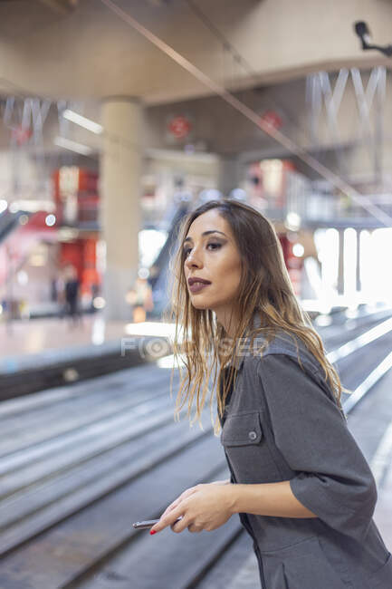 Fiduciosa donna in piedi sulla stazione ferroviaria — Foto stock