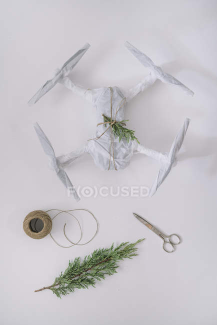 Drone wrapped as Christmas gift with fir branch and twine on white background — Stock Photo