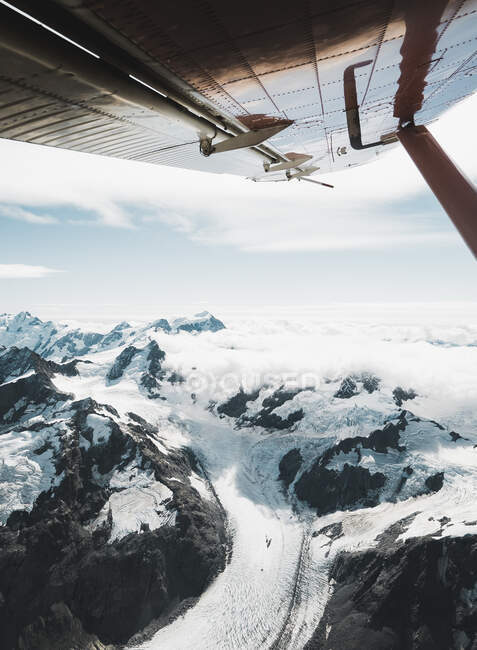 Picturesque view of snowy ridge of Aoraki mountain under wing of modern aircraft on cloudy day in New Zealand — Stock Photo