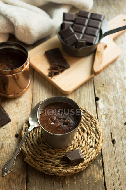 Heiße Schokoladentasse mit Schokoladenstücken auf Holztisch — Stockfoto