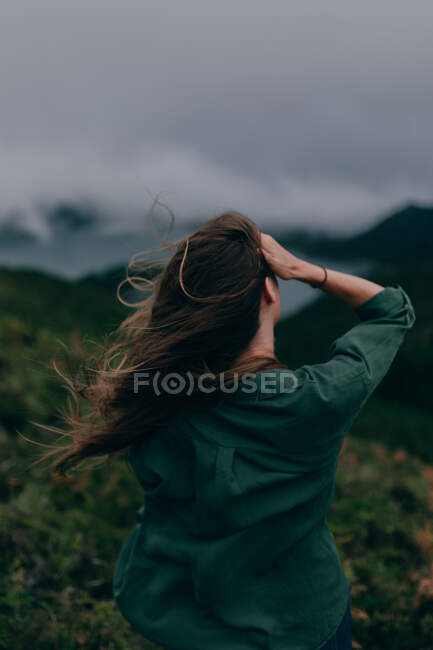 Donna in piedi su un'alta collina con lago sottostante — Foto stock