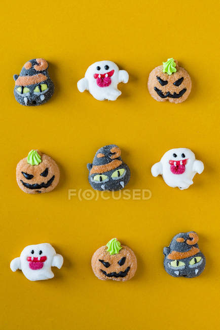 Caramelos de Halloween decorados sobre fondo naranja - foto de stock