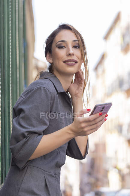 Frau benutzt Smartphone in der Nähe von Haus auf Straße — Stockfoto
