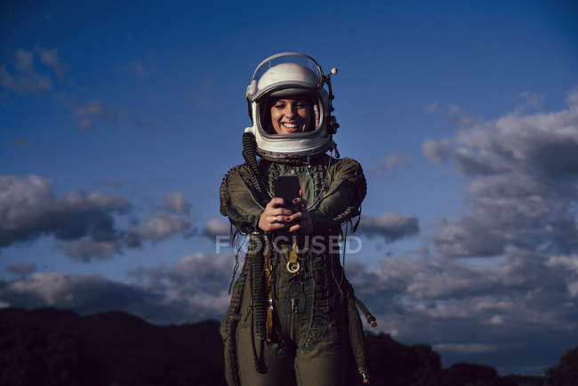 Femme astronaute souriante prenant selfie téléphone portable en soirée nature — Photo de stock