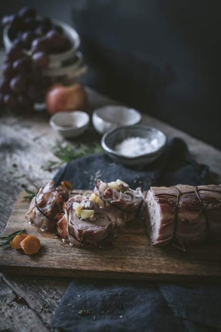 Свиная вырезка на деревянном столе со специями и ингредиентами — стоковое фото