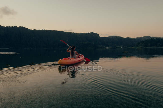 Femme naviguant sur le bateau dans le lac pur — Photo de stock