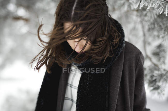 Jovem fêmea em roupas quentes andando no dia de inverno ventoso no campo magnífico — Fotografia de Stock