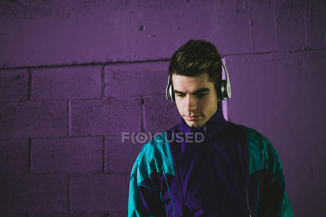 Young man in sportswear listening to music with headphones — Stock Photo