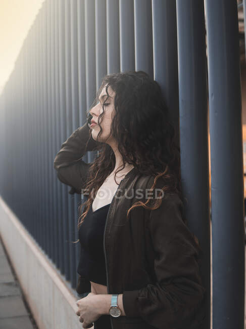 Молодая женщина, опирающаяся на забор — стоковое фото