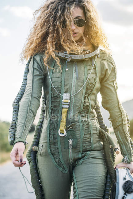 Жіночий астронавт з Кучеряве волосся, гуляючи по дорозі в природі — стокове фото
