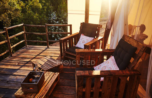 Деревянные стулья с подушками в палатке на закате — стоковое фото