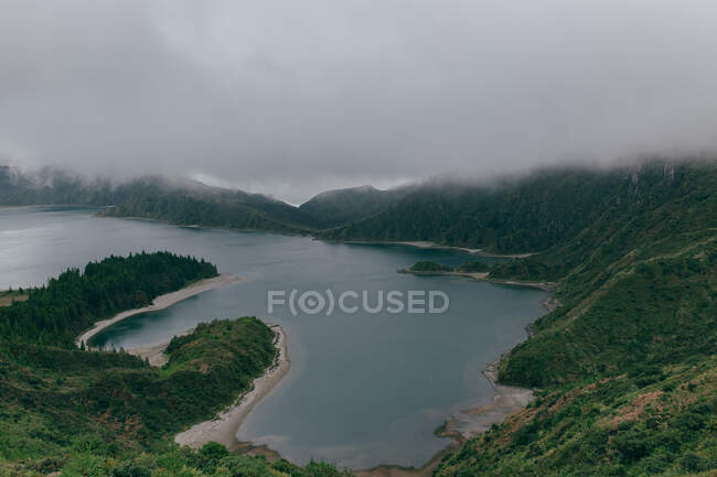 Lago con costa collinare — Foto stock