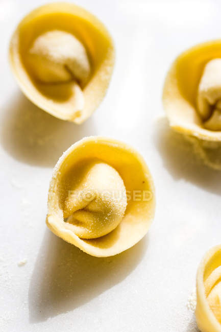 Close-up of uncooked tortellini on white tabletop — Stock Photo