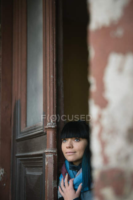 Donna dalla porta guardando lontano — Foto stock