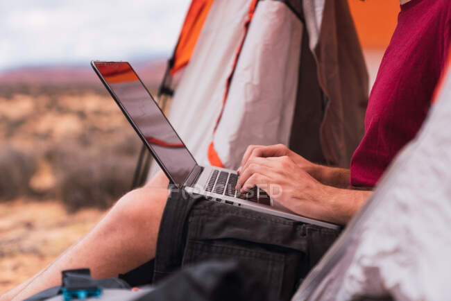 Viaggiatore che utilizza il computer portatile in una tenda — Foto stock
