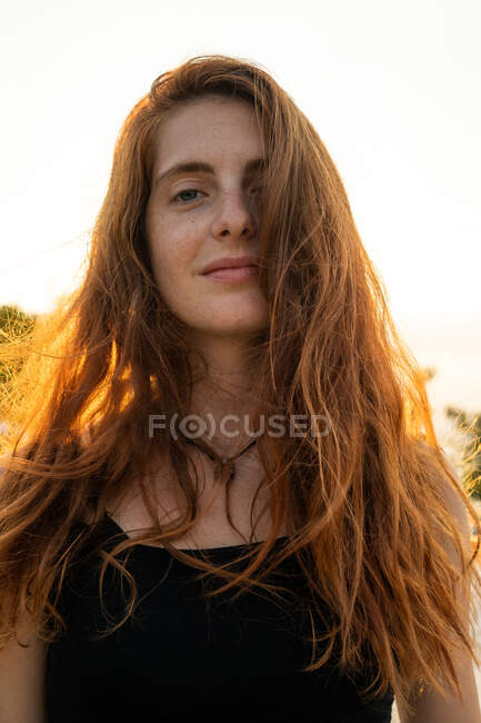 Atraente jovem fêmea sorrindo e olhando para a câmera enquanto estava de pé no fundo borrado de natureza incrível no dia ensolarado na Bulgária, Balcãs — Fotografia de Stock
