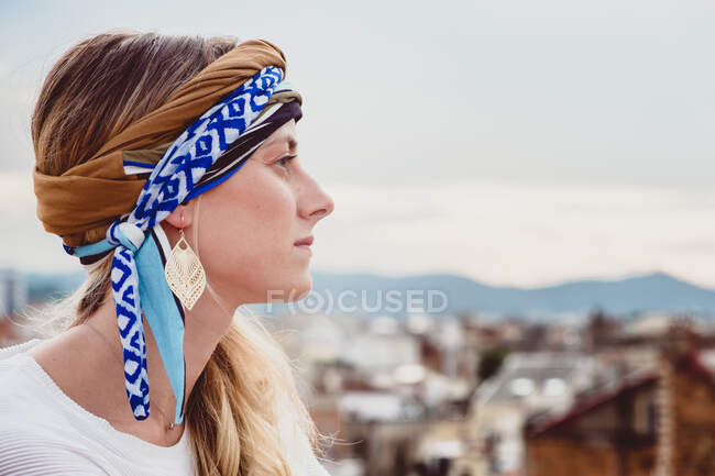 Жінка в одязі голови стоїть на даху — стокове фото