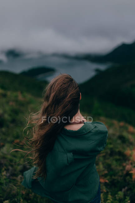 Mulher de pé em alta colina com lago abaixo — Fotografia de Stock