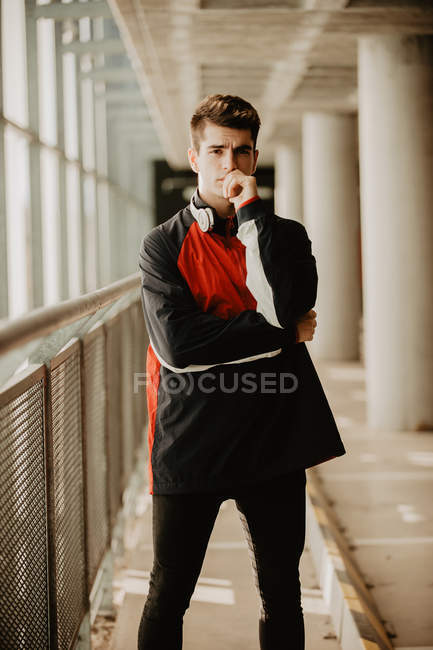 Молодий вдумливий чоловік стоїть всередині будівлі зі стовпами — стокове фото