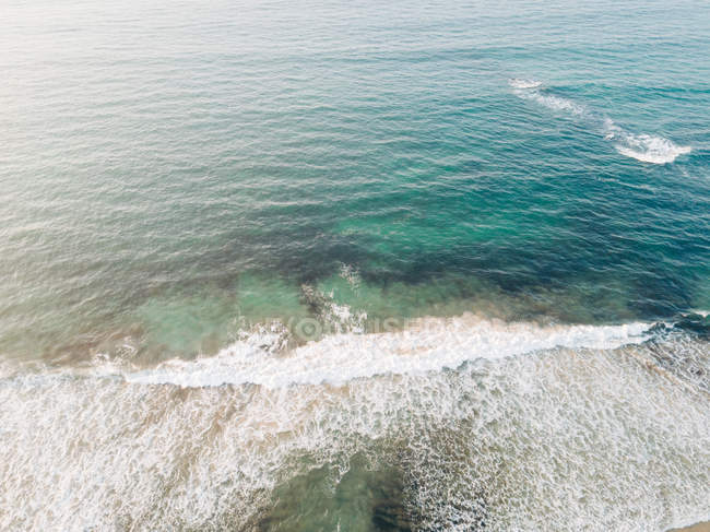 Рябь голубой поверхности морской воды возле пляжа — стоковое фото