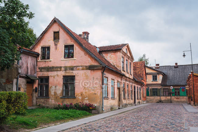 Strada di pietra e case fatiscenti invecchiate su strada di piccola città durante giorno nuvoloso — Foto stock