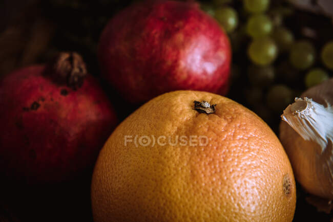 Корзина с апельсинами, виногранатами и гранатами на столе — стоковое фото