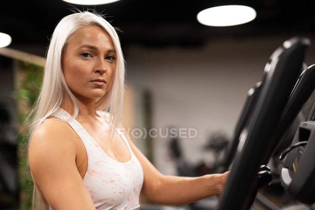 Portrait of blond woman standing on stepper — Stock Photo