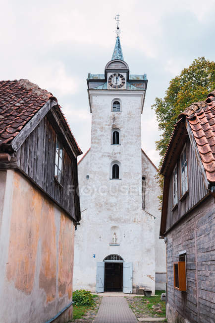 Два бурхливі будинки біля чудової старої церкви в похмурий день у маленькому містечку — стокове фото