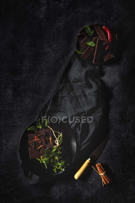 Schokolade mit roter Chilischote, Minze und Zimt auf dunklem Hintergrund — Stockfoto