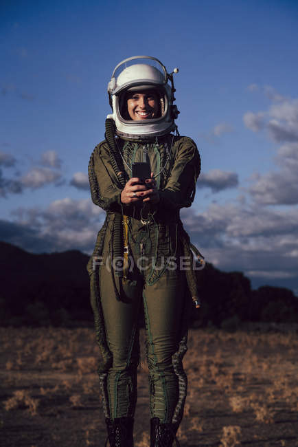 Sorridente astronauta donna scattare selfie cellulare in natura sera — Foto stock