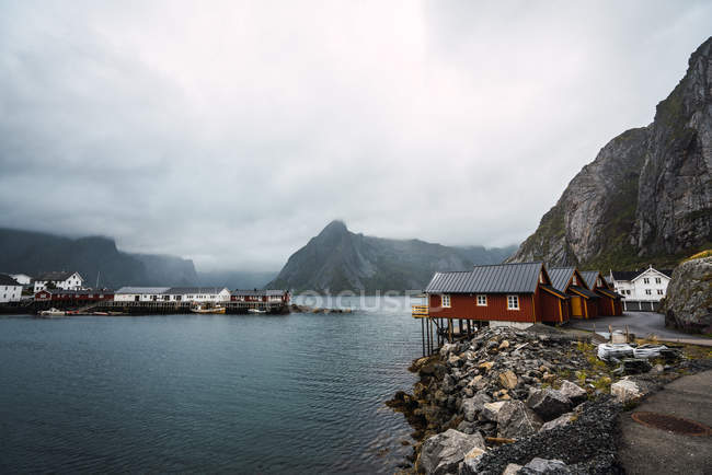Cais com casas de madeira na costa do mar rochoso em montanhas — Fotografia de Stock