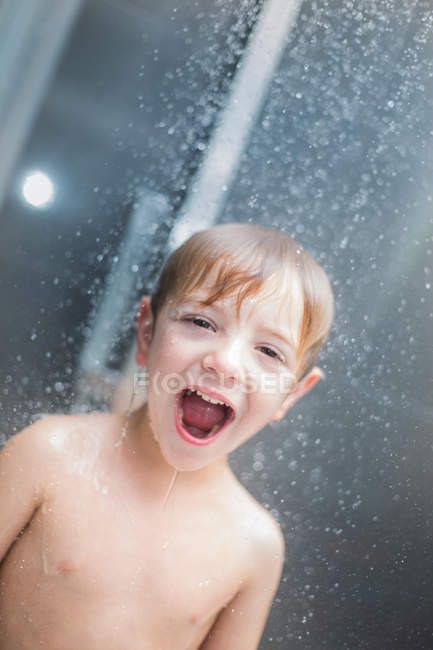 Грайливий маленький хлопчик кричить під водою в душі — стокове фото