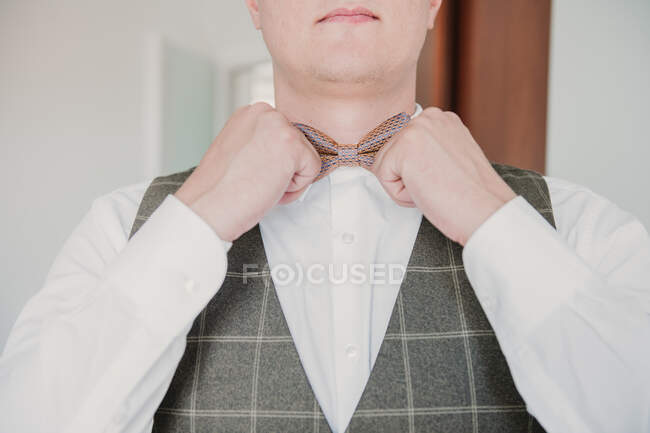 A groom groom adjusting his bow tie — Stock Photo