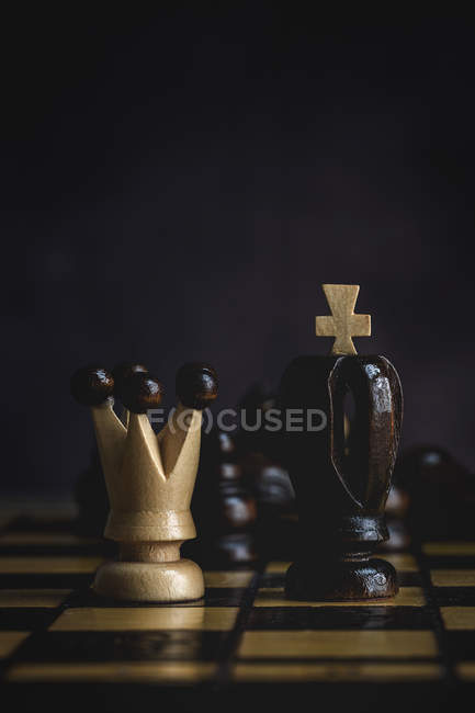 Primer plano de Juego y piezas de ajedrez sobre fondo oscuro - foto de stock