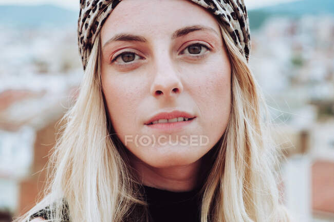 Mujer rubia joven en tela de la cabeza mirando a la cámara - foto de stock