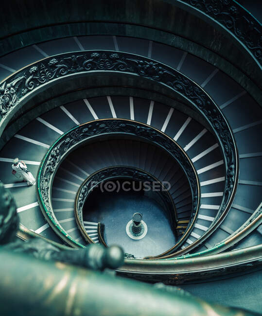 Dall'alto colpo di persona irriconoscibile che scende dalle scale a chiocciola a Roma — Foto stock