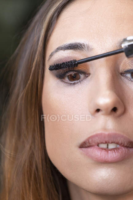 Crop hands applying mascara on model — Stock Photo