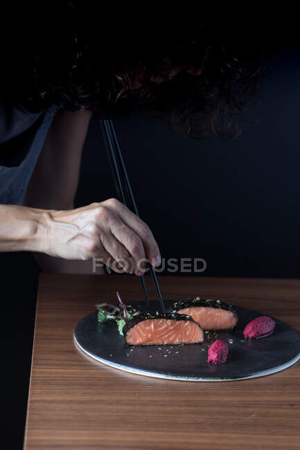 Жінка говорить смачне філе лосося з паличками — стокове фото