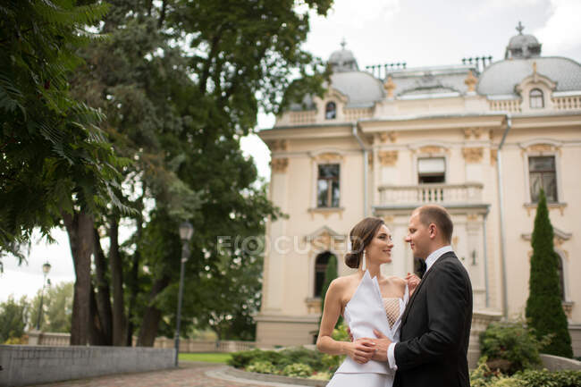 Casal casal abraçando perto de edifício de luxo — Fotografia de Stock
