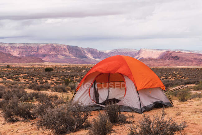 Tenda turistica vuota in piedi in mezzo al magnifico deserto nella giornata nuvolosa — Foto stock