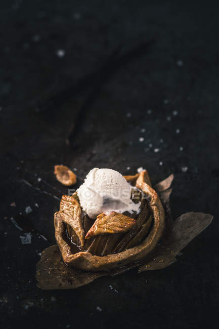 Deliciosa mini galette de manzana con bola de helado dulce en pergamino pieza - foto de stock