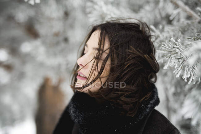 Jovem fêmea em roupas quentes andando no dia de inverno ventoso no campo magnífico — Fotografia de Stock