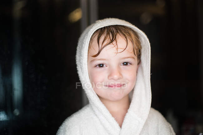 Портрет усміхненого маленького хлопчика з мокрим волоссям у халаті — стокове фото