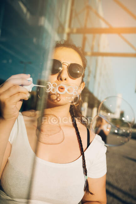 Jeune femme soufflant des bulles — Photo de stock