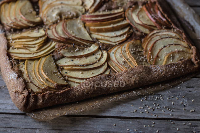Homemade sesame and apple pie on wooden tabletop — Stock Photo