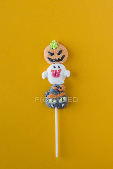 Bonbons d'Halloween sur bâton sur fond orange — Photo de stock