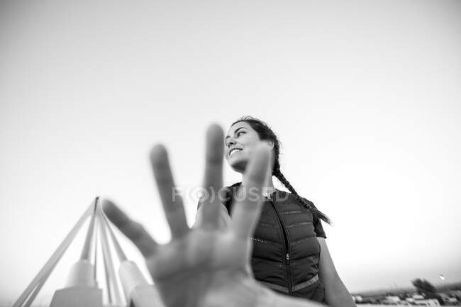 Щаслива жінка в сонячному світлі простягає руку — стокове фото