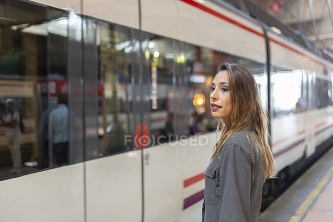 Уверенная женщина стоит на железнодорожной станции — стоковое фото