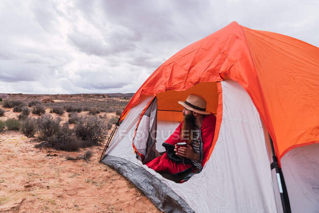 Uomo con tazza in una tenda nel Grand Canyon — Foto stock