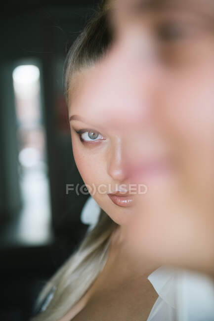 Jeune femme attrayante en robe de mariée blanche regardant la caméra — Photo de stock